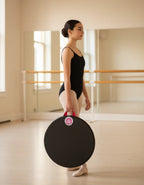 A young dancer in a dance studio holding The Pink Handle Edition by its pink handle